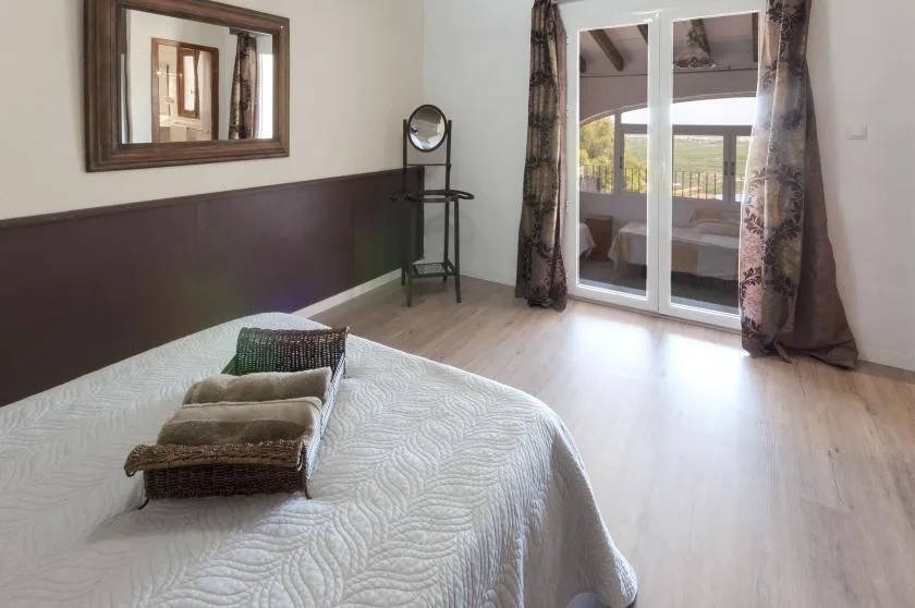 A bedroom with a bed and sliding glass doors opening onto a balcony.