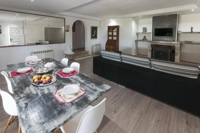 A dining area with a set table faces a living area with a television.