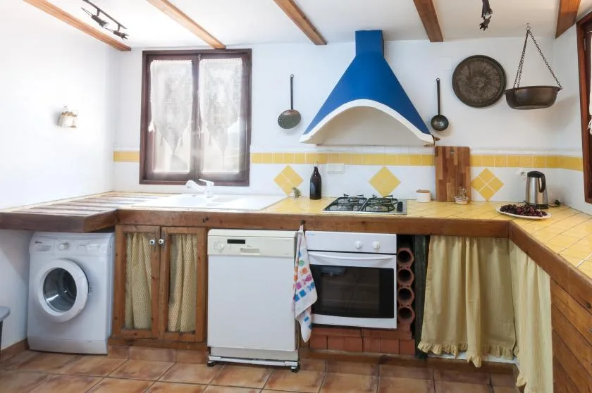 A kitchen with a blue range hood above the countertop and stove.