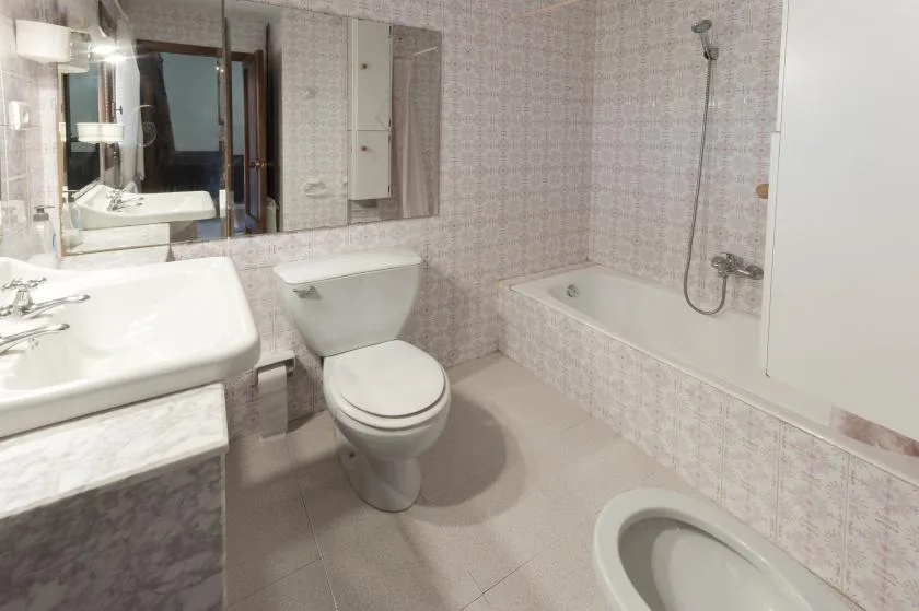 A tiled bathroom with a sink, toilet, and bathtub.