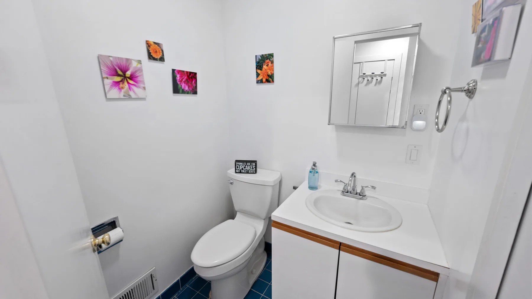 A small bathroom with a toilet and a sink beneath a mirrored cabinet.