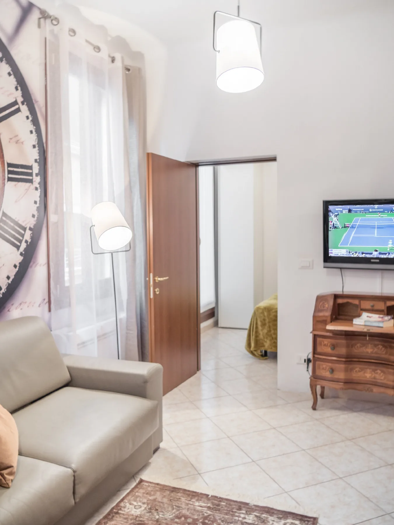 A bright living room with seating, a television, and an open doorway.