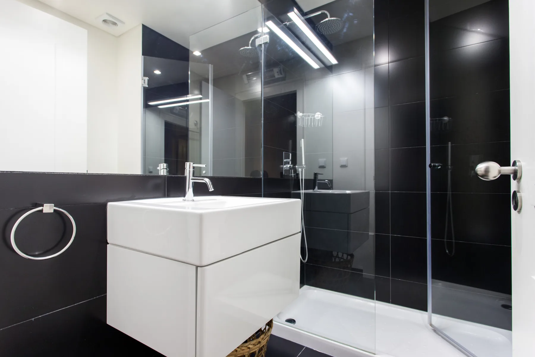 Un baño moderno con un lavabo blanco y una ducha de vidrio.