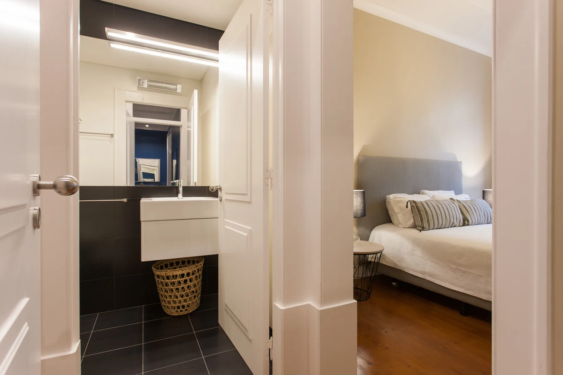 Se ve un dormitorio con cama junto a un lavabo de baño.
