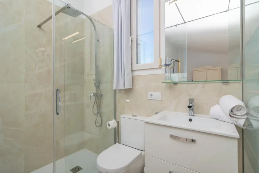 A bathroom with a glass shower and a white vanity.
