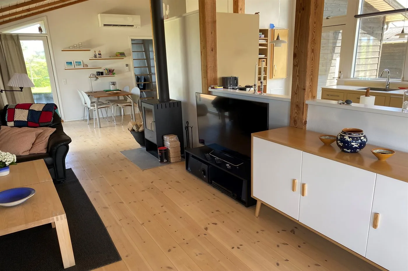 Sala y comedor de concepto abierto con una barra de cocina y piso de madera.