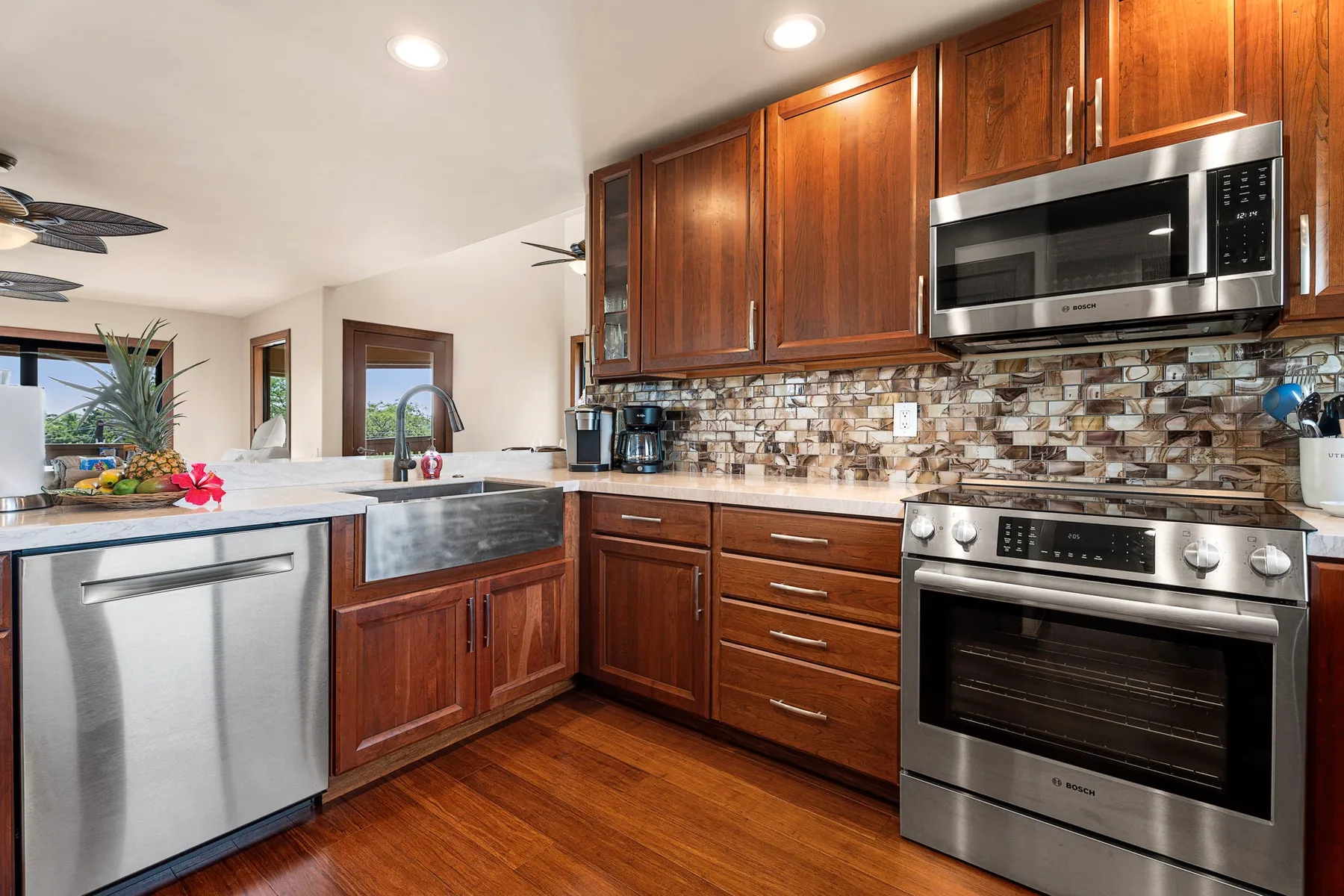 A kitchen with wooden cabinets, stainless steel appliances, and a tiled backsplash.