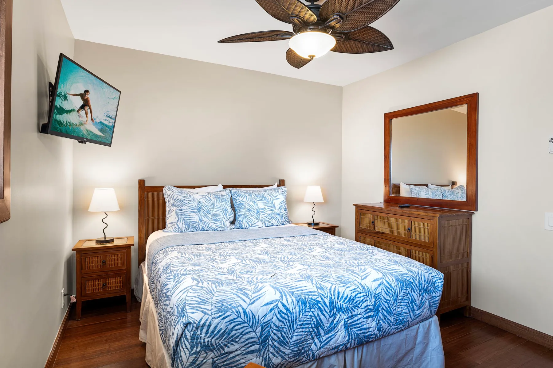 A bedroom with a bed dressed in blue and white patterned bedding.