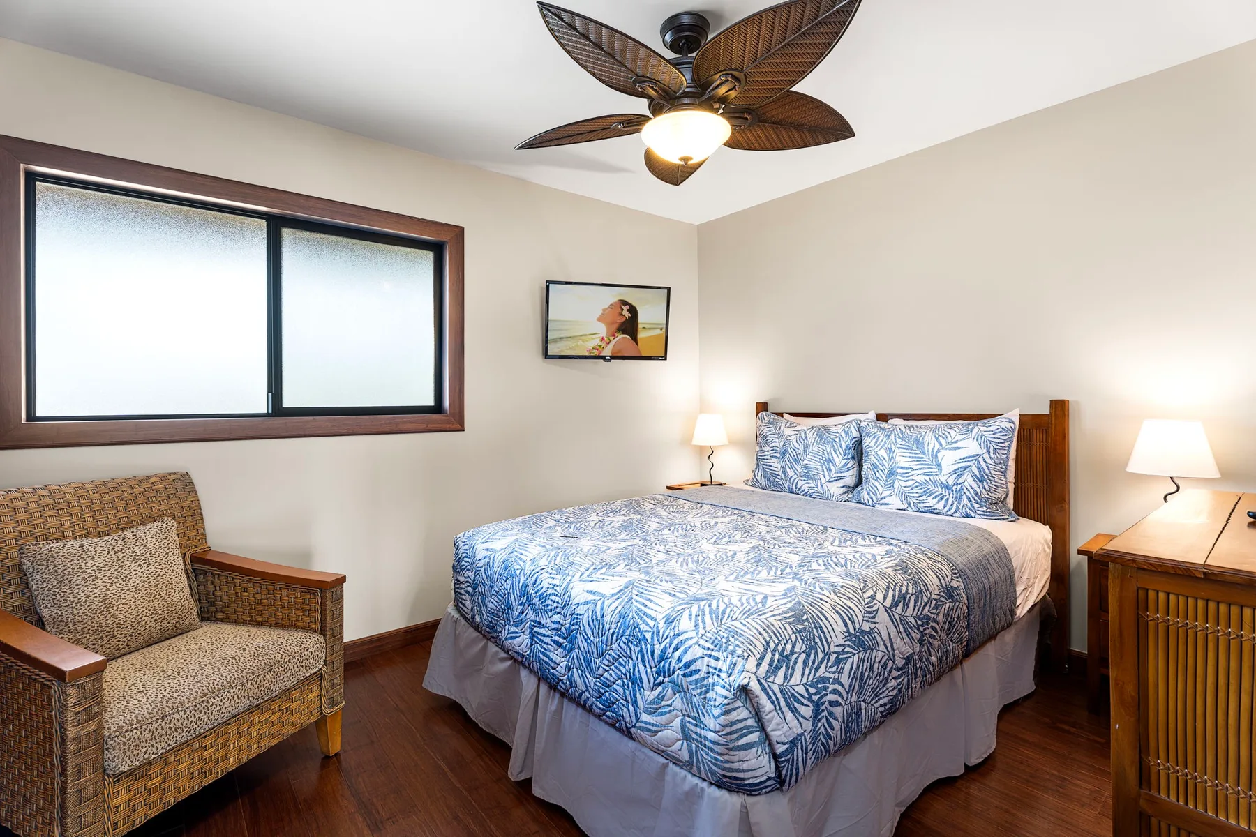 A bedroom with a bed, bedside tables, and a ceiling fan.