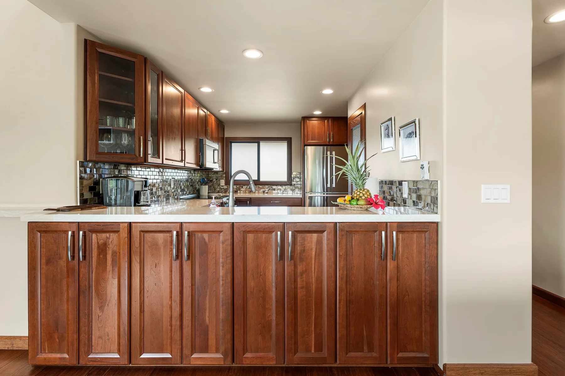 A kitchen with dark wood cabinets, a countertop, and a sink.