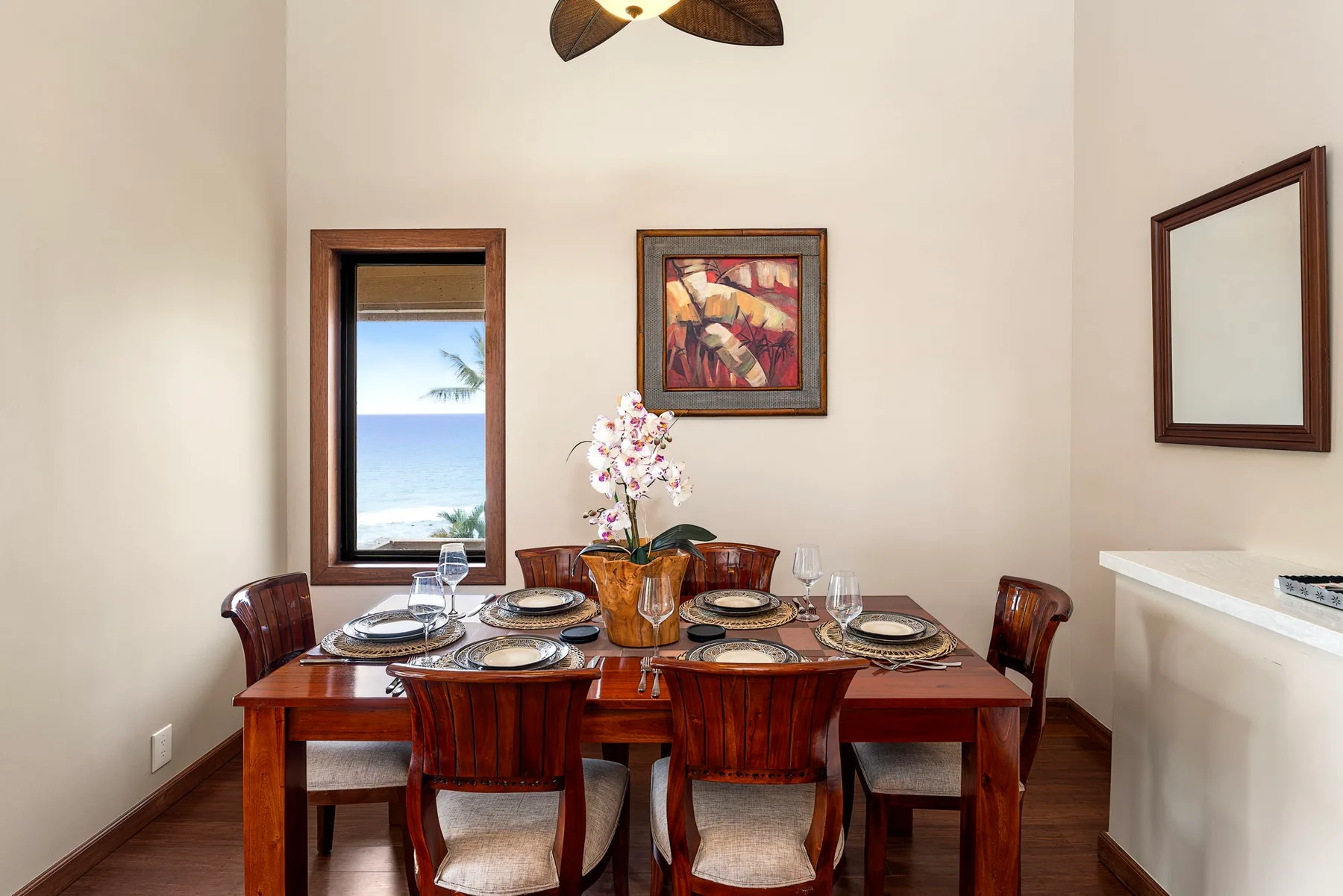 Comedor con una mesa de madera puesta y flores.