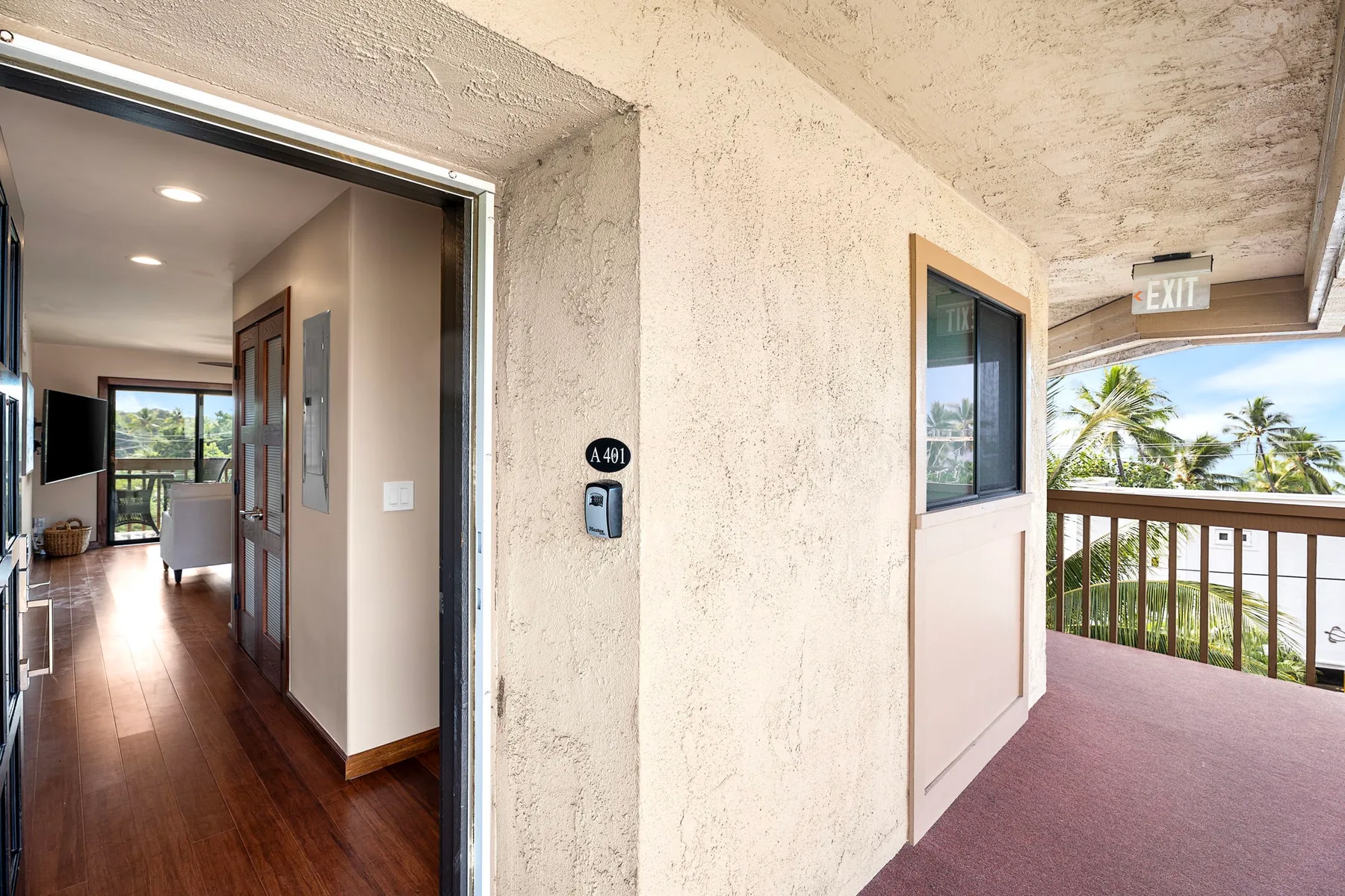 An open doorway leads from an interior hallway to a covered balcony with a railing.