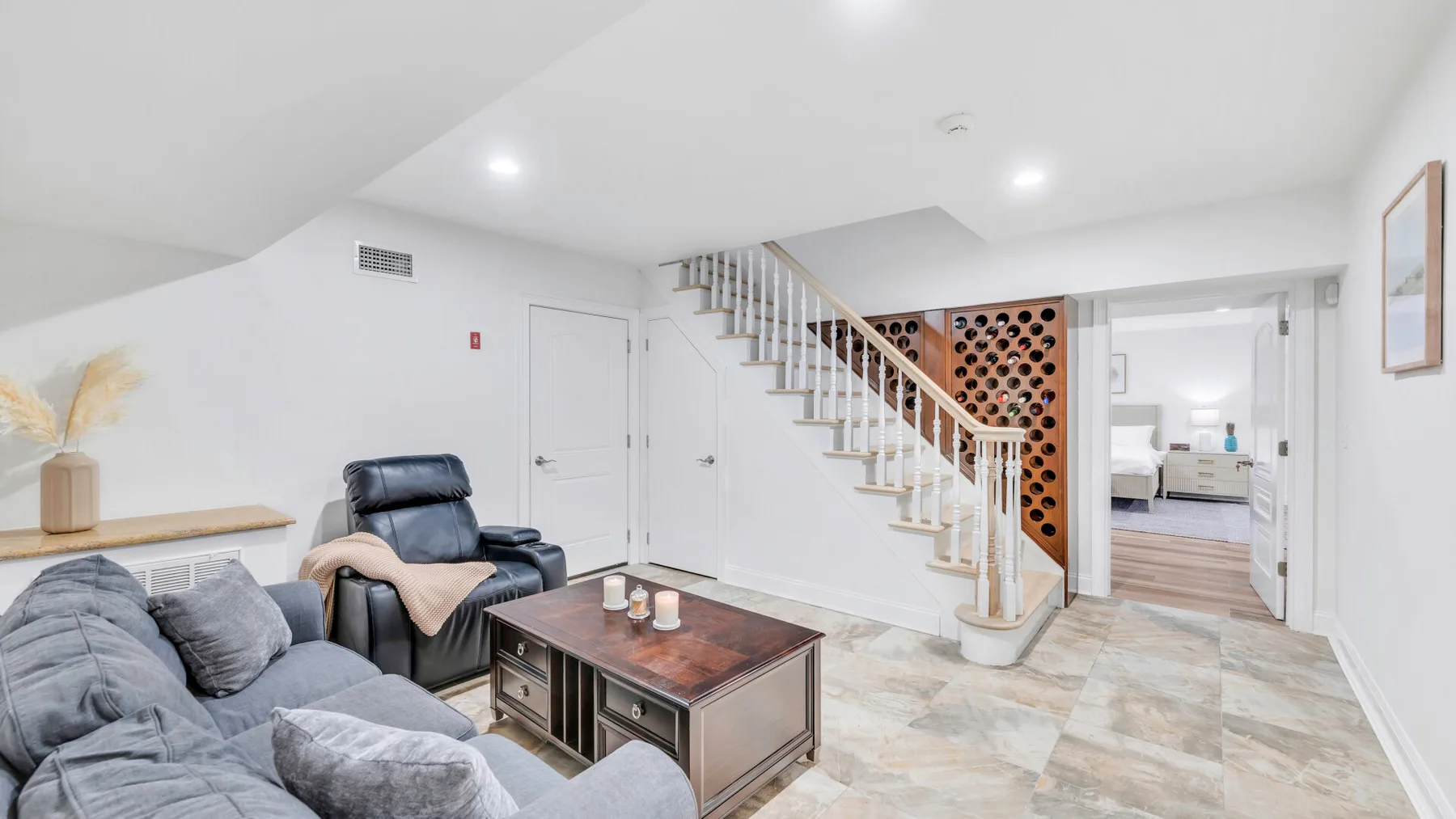 A bright living area with seating, a coffee table, and a staircase.