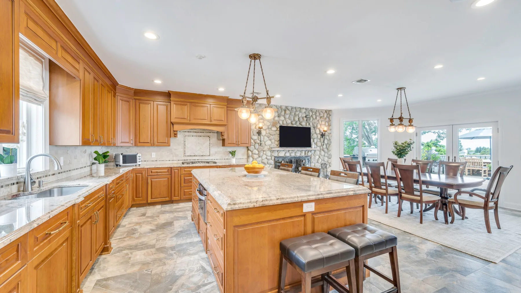 An open kitchen and dining area with wooden cabinetry and a central island.
