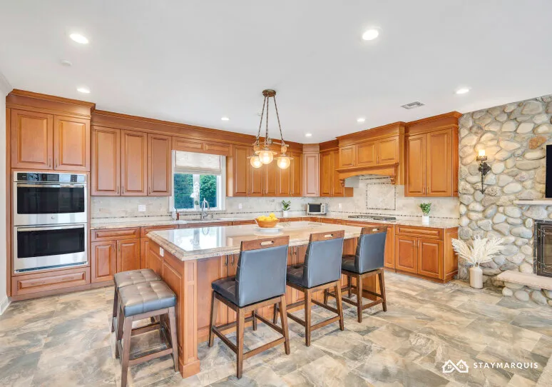 A spacious kitchen with wooden cabinetry and a central island with seating.