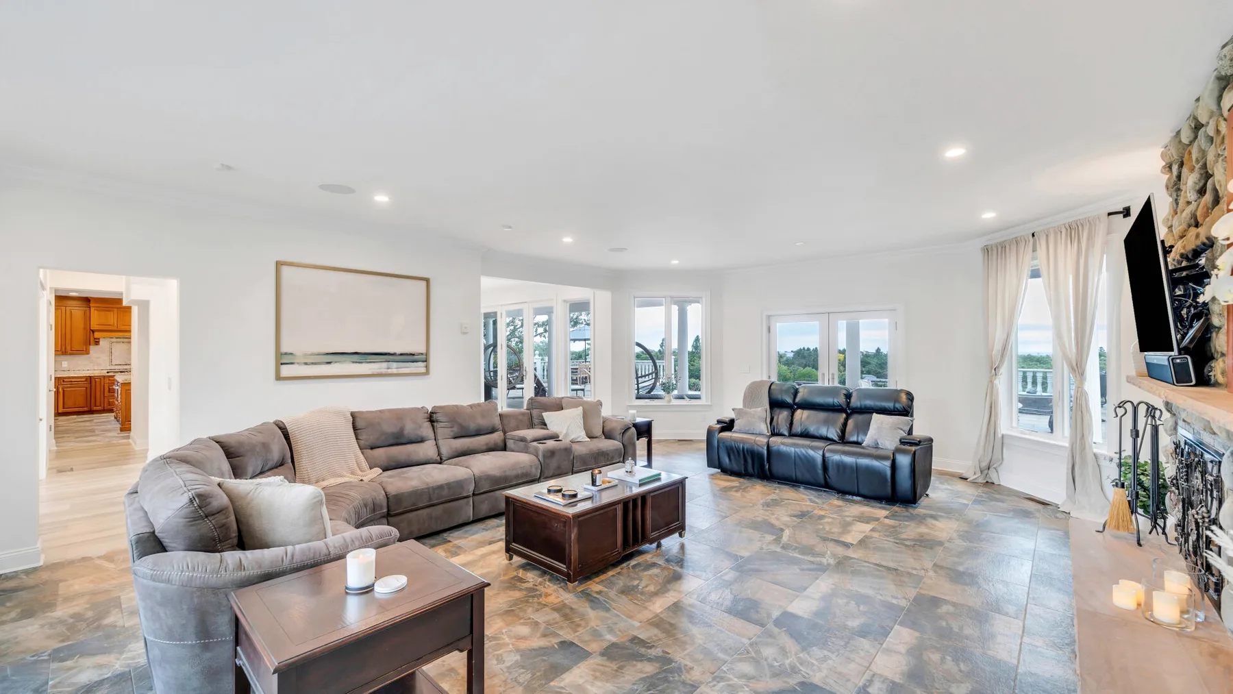 A bright living room with seating, a coffee table, and large windows.