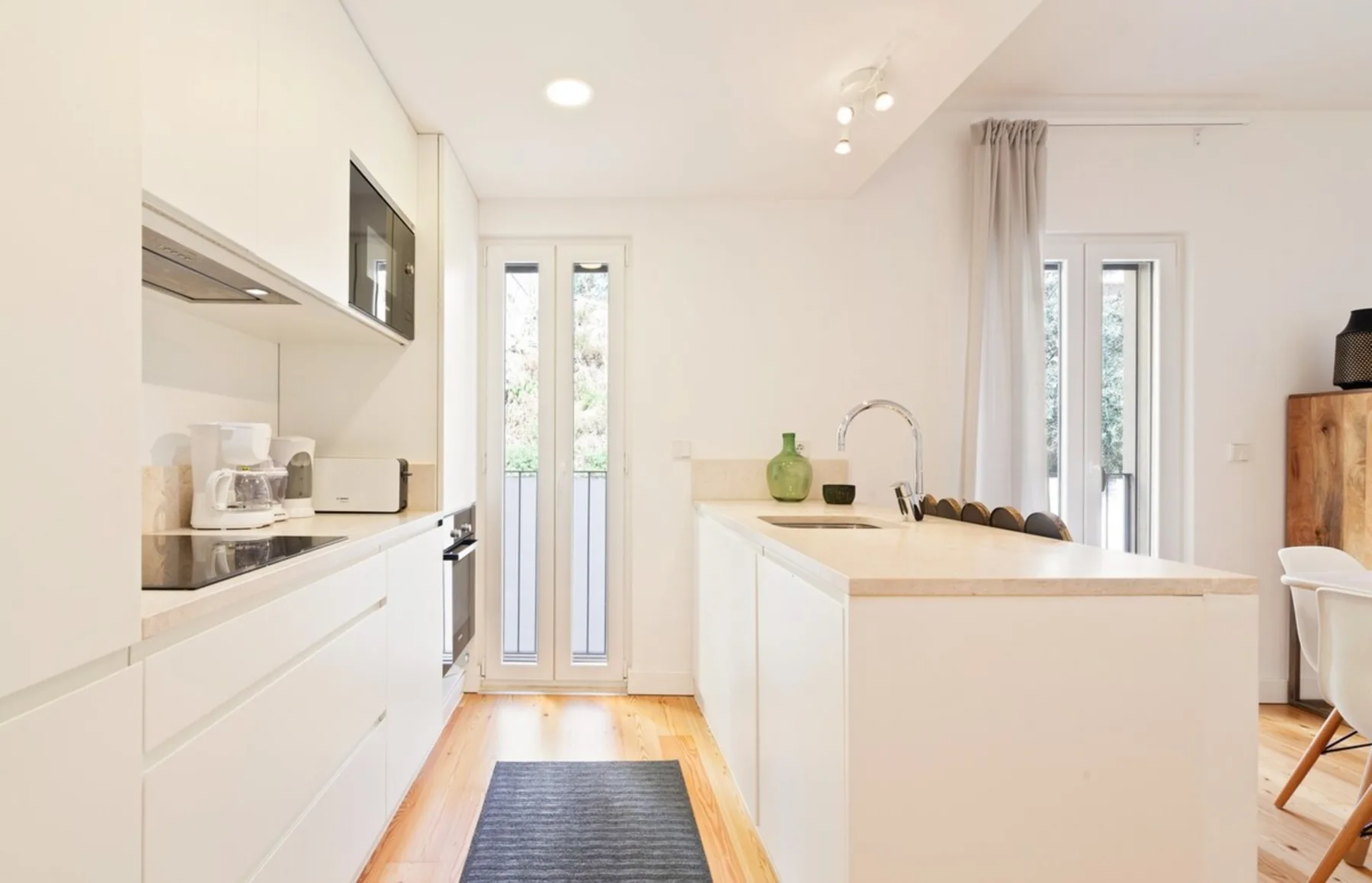 A bright kitchen with white cabinetry and a central island.