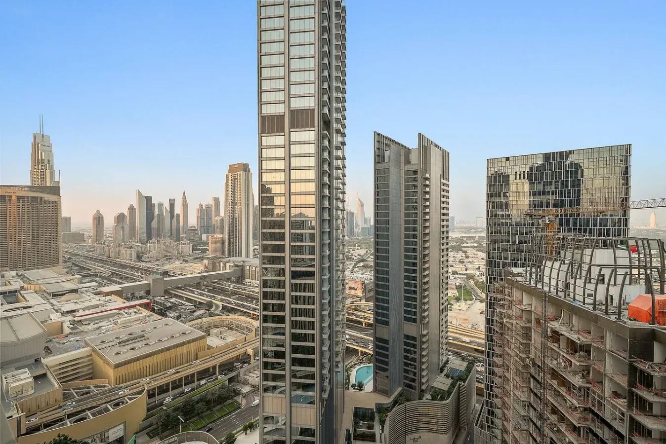 A city skyline with tall buildings and elevated roadways under a clear sky.