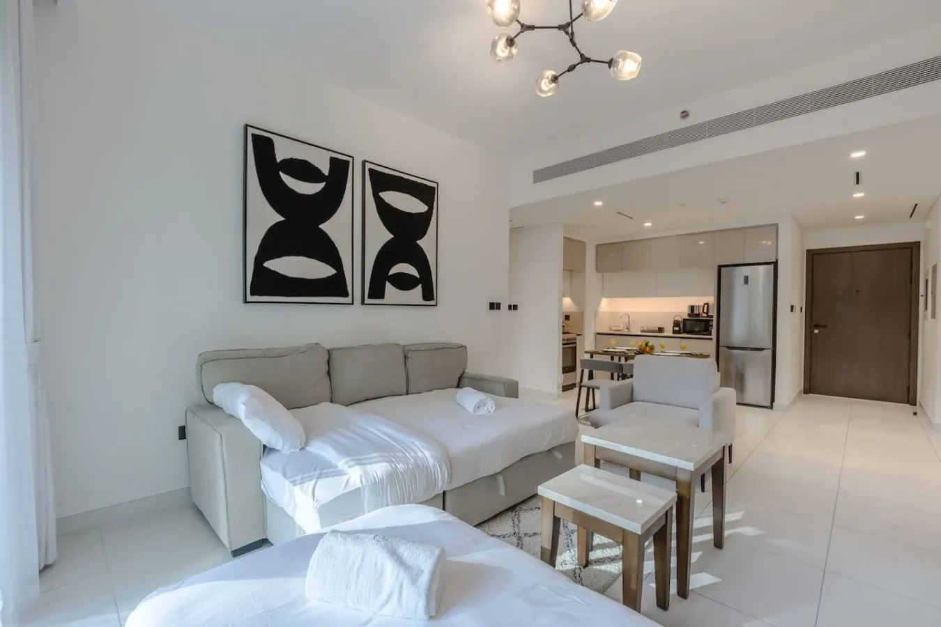 Una sala luminosa con una zona de asientos y una cocina abierta.