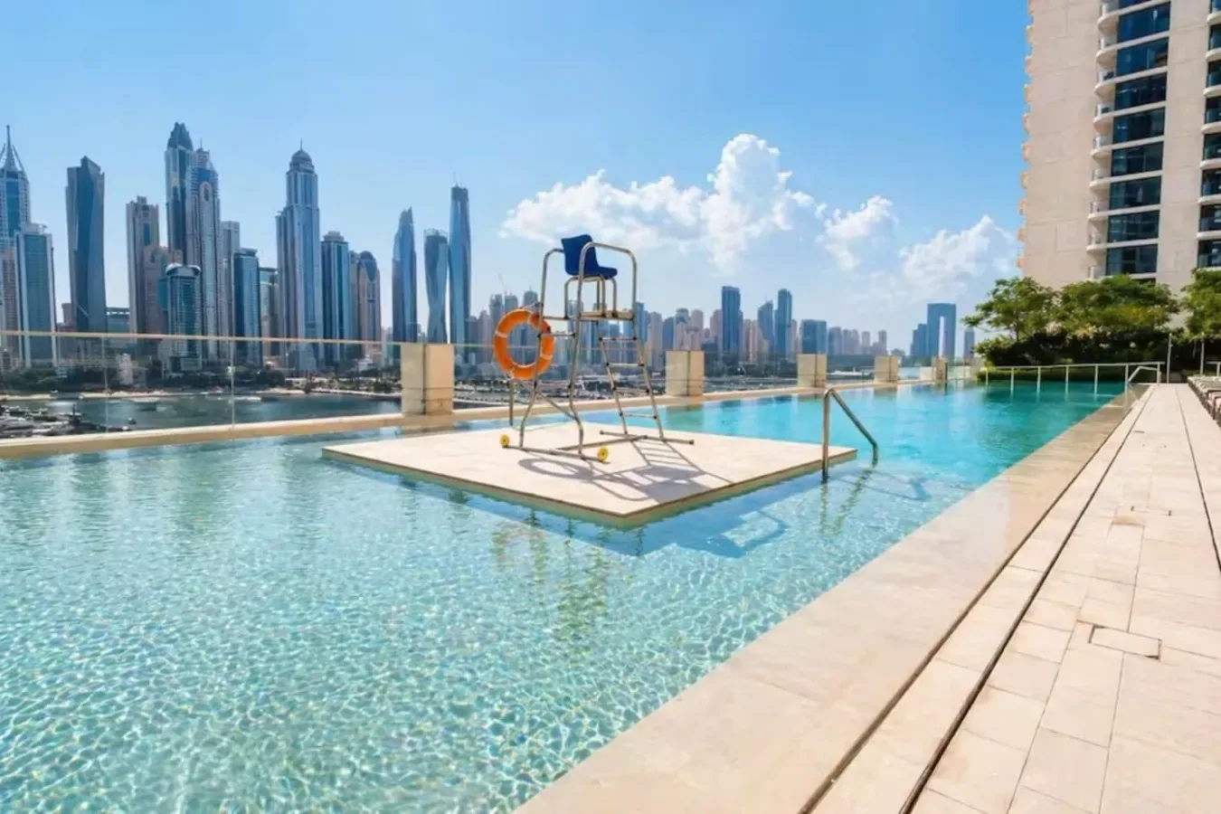 Una piscina en la azotea ofrece vistas del perfil urbano, con una silla de socorrista sobre una plataforma.