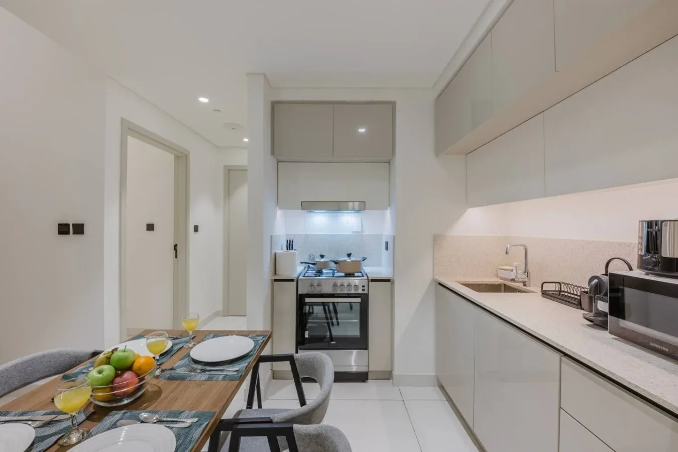 Una cocina luminosa con mesa de comedor y zona de cocción integrada.