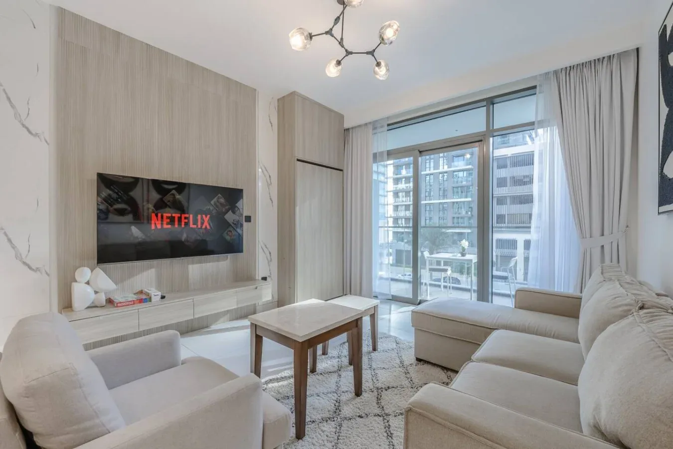 Una sala luminosa con asientos, una mesa de centro y ventanales.
