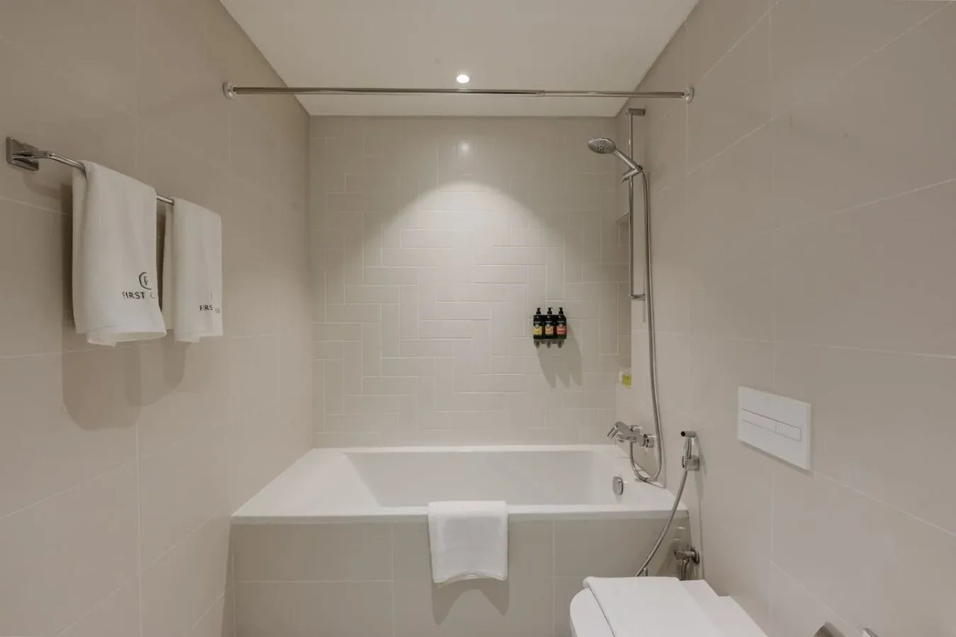 Un baño alicatado con bañera, ducha y toallas.