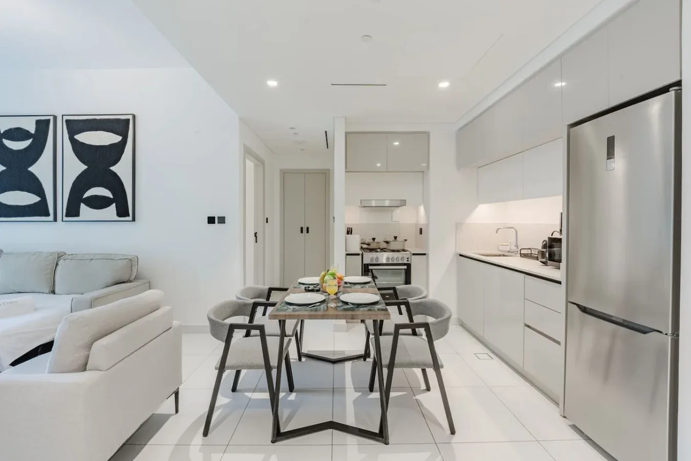 Sala de estar y cocina de planta abierta, con una mesa de comedor en primer plano.