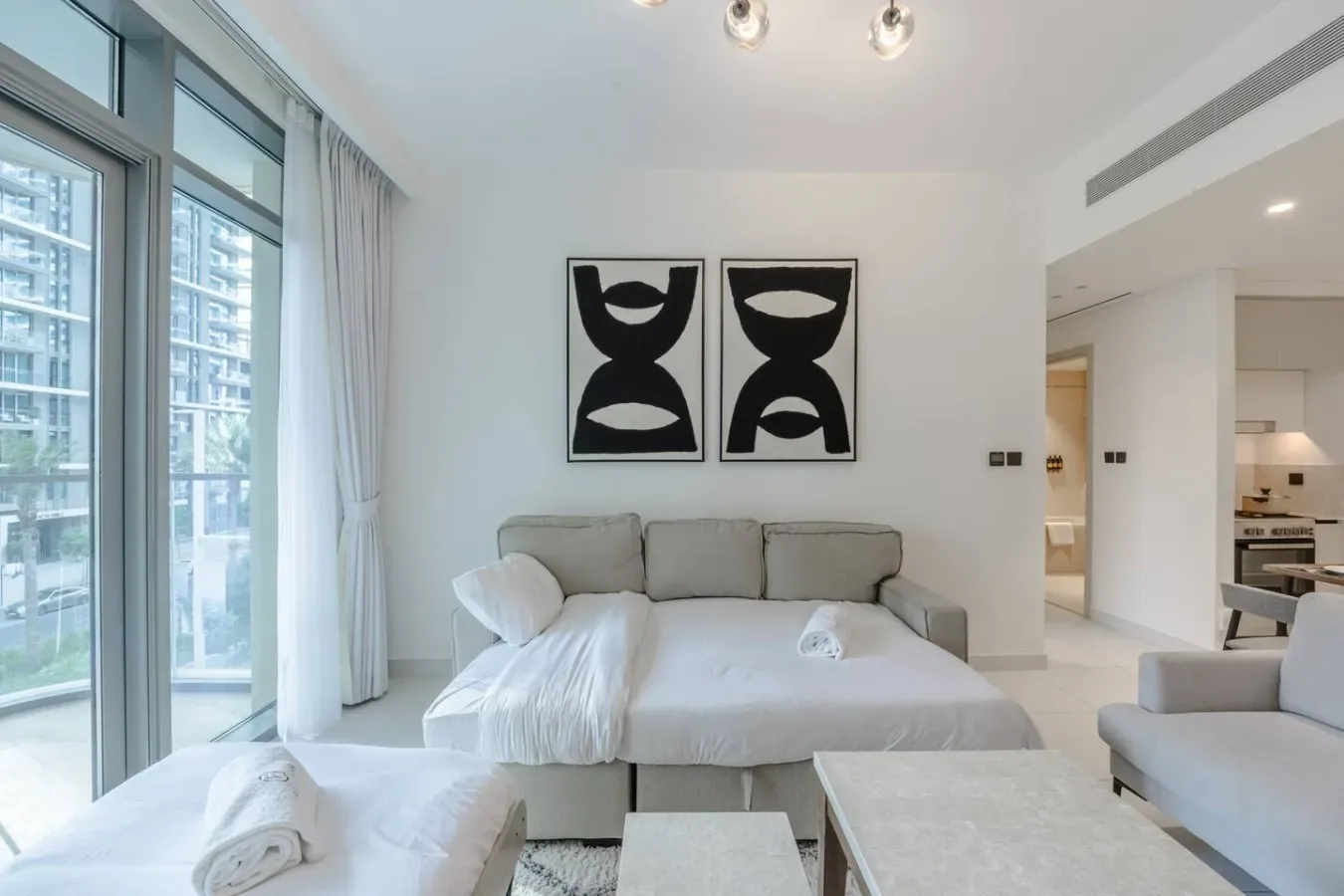 Una sala luminosa con una cama, asientos y ventanales.