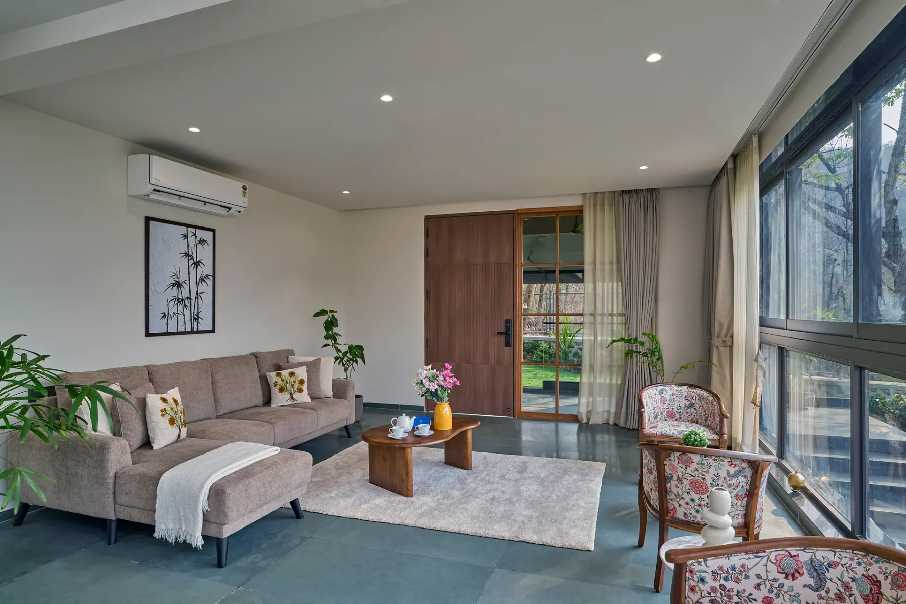 Sala de estar con asientos, una mesa de centro y ventanas grandes.