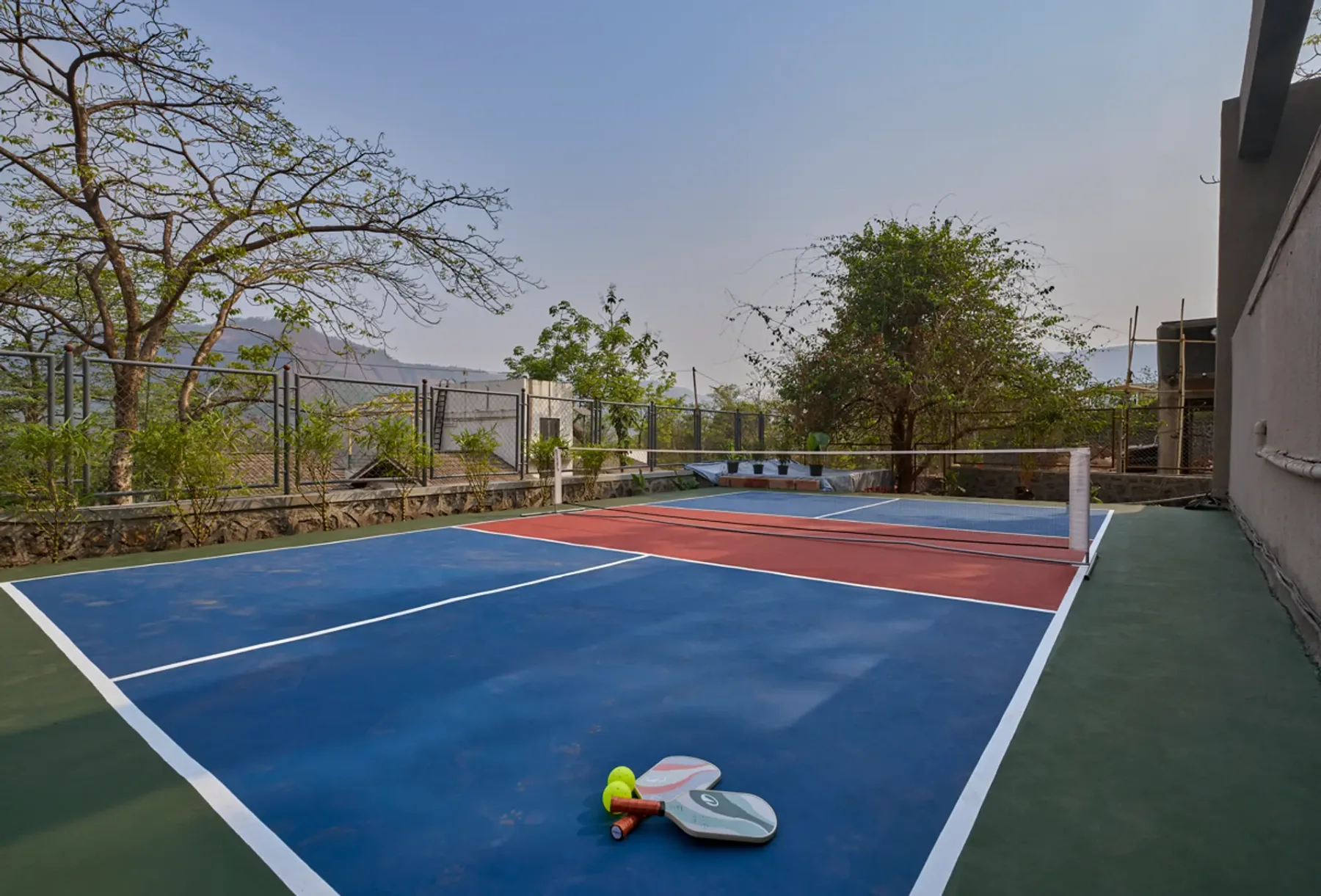 Una cancha colorida al aire libre está rodeada de árboles y una cerca.