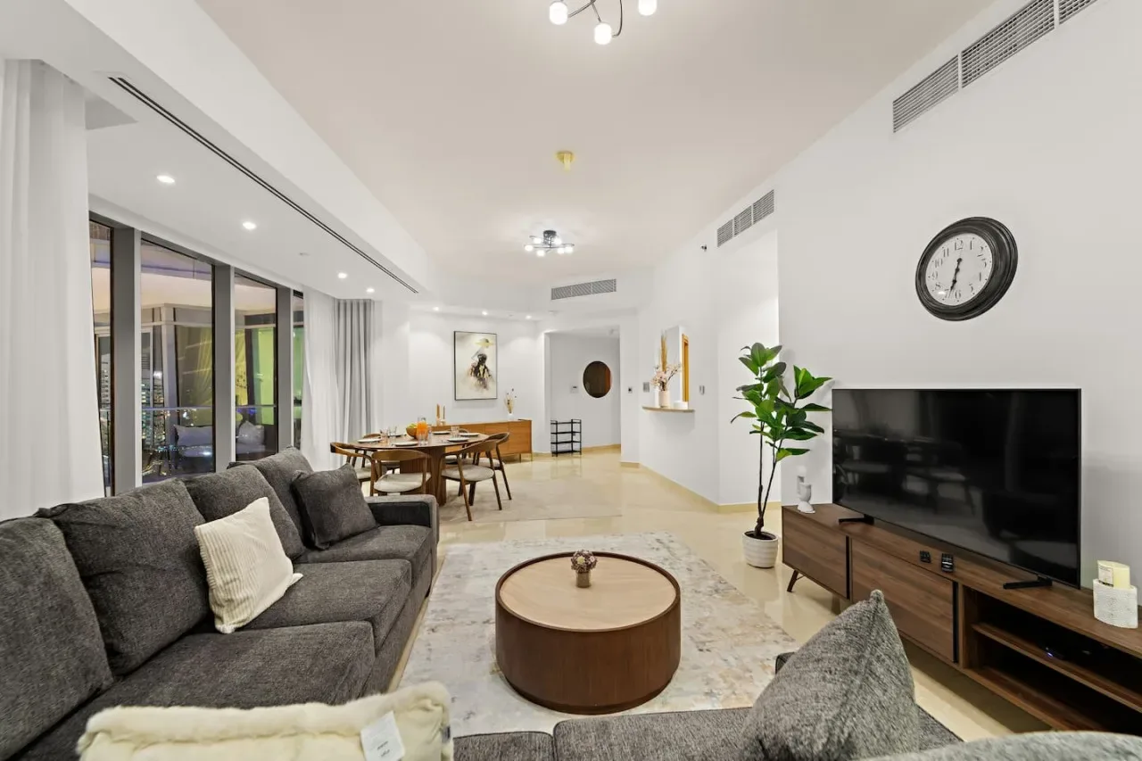 Una sala luminosa con asientos, una mesa de centro y un televisor.