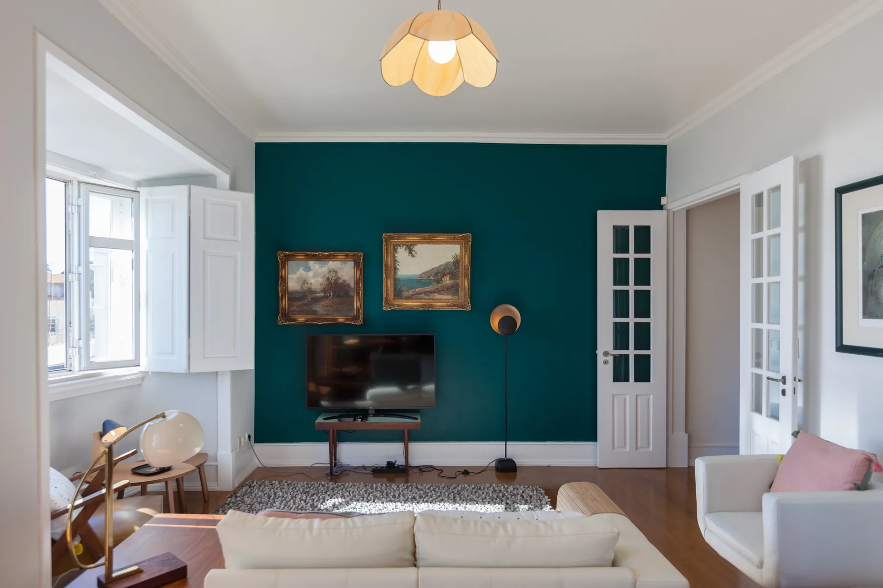 Living room with seating facing a television against a teal wall.