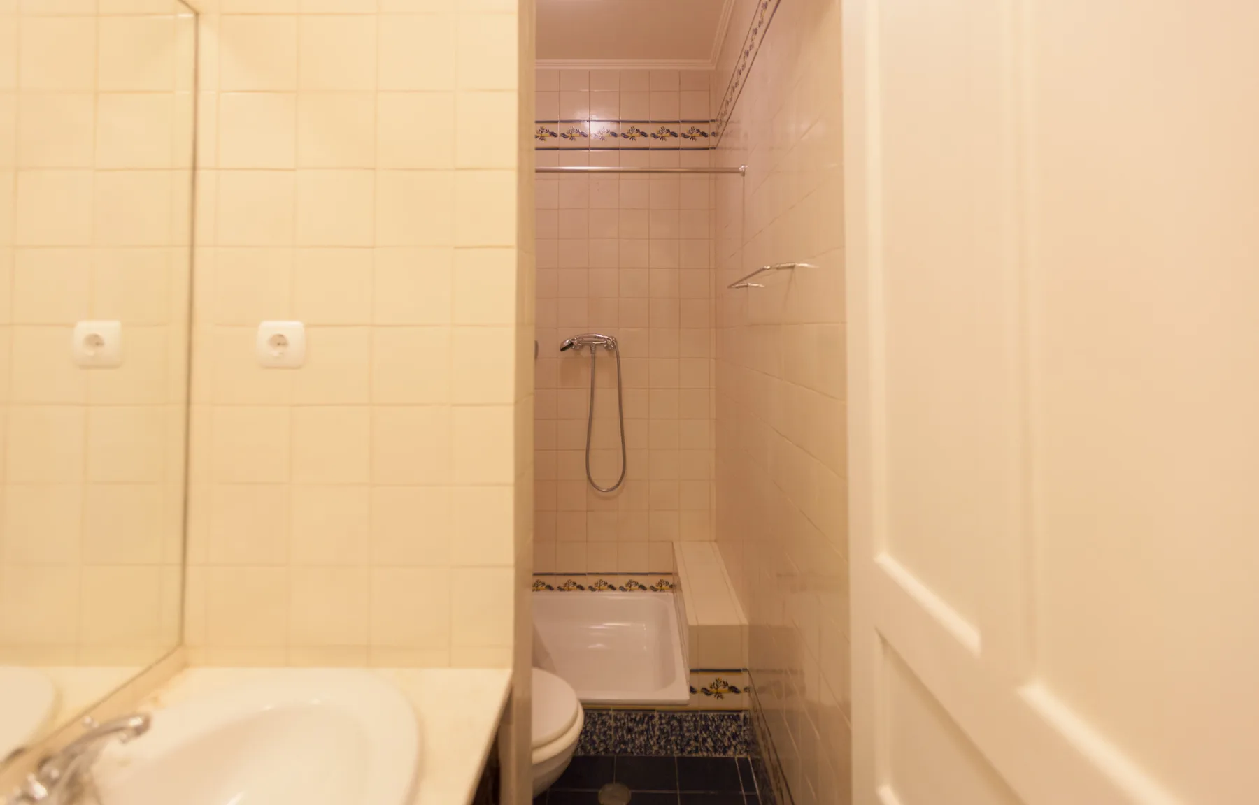 A tiled bathroom with a shower and sink.