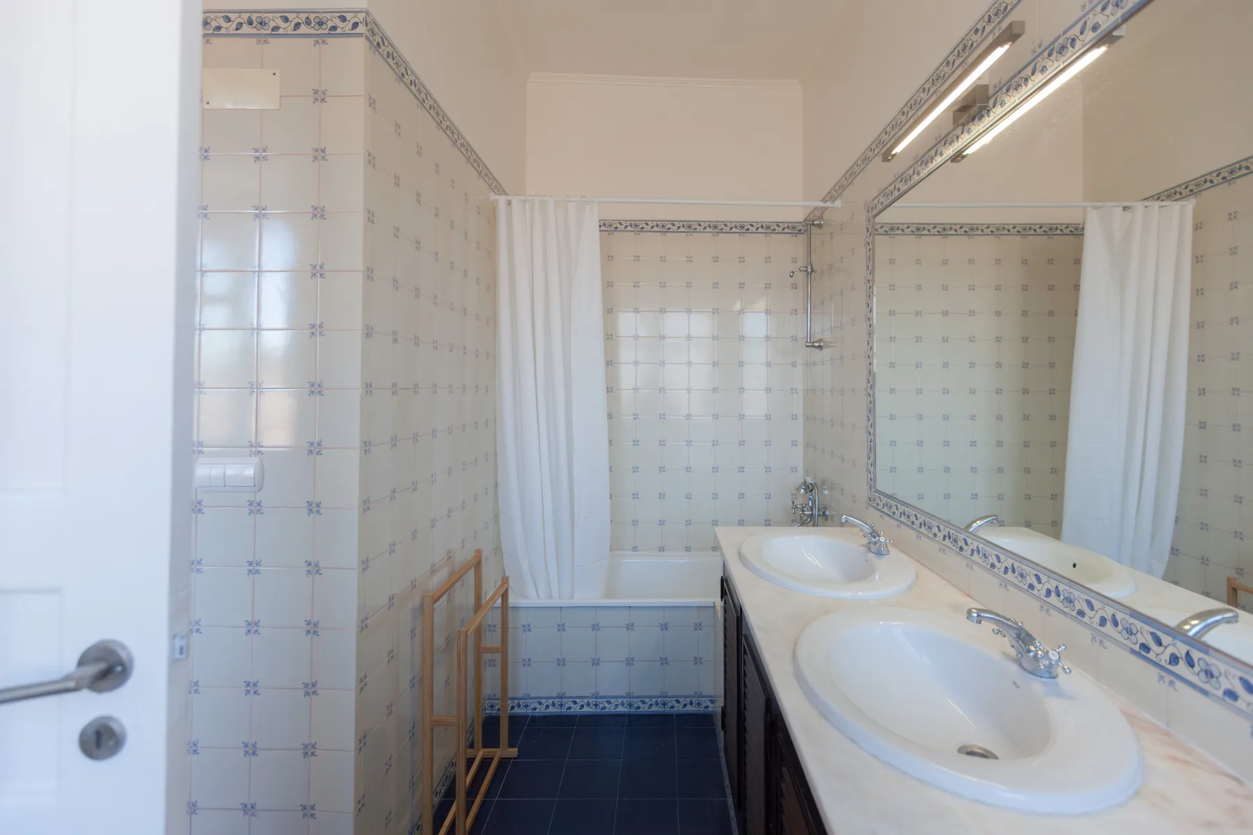 A tiled bathroom with a bathtub and a double-sink vanity.