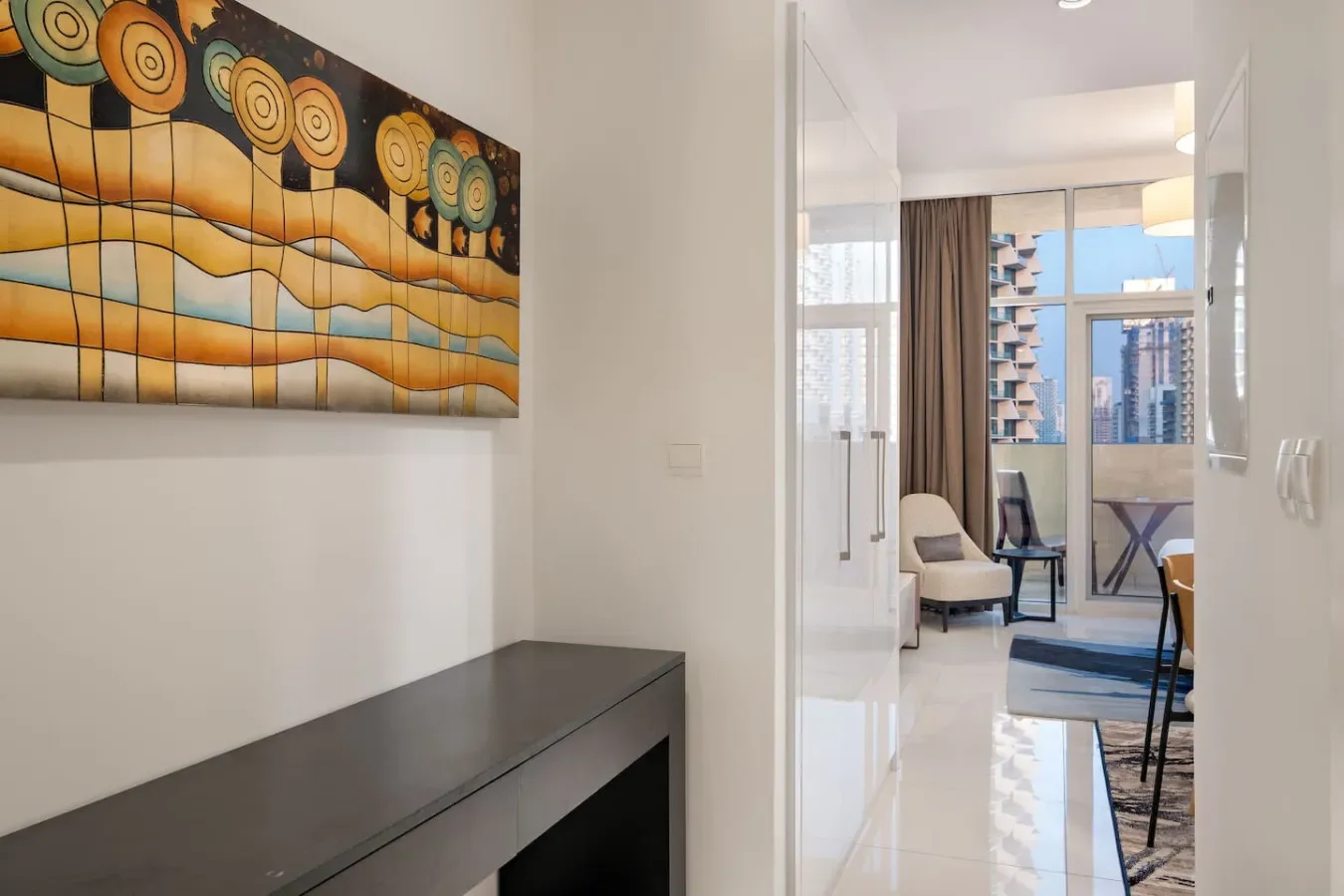 A bright interior hallway opens into a sitting area with large windows.