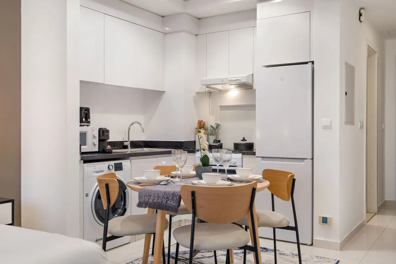 A bright kitchen and dining area with a table set for a meal.