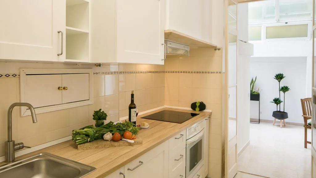 Una cocina luminosa con encimera y una zona de comedor contigua.