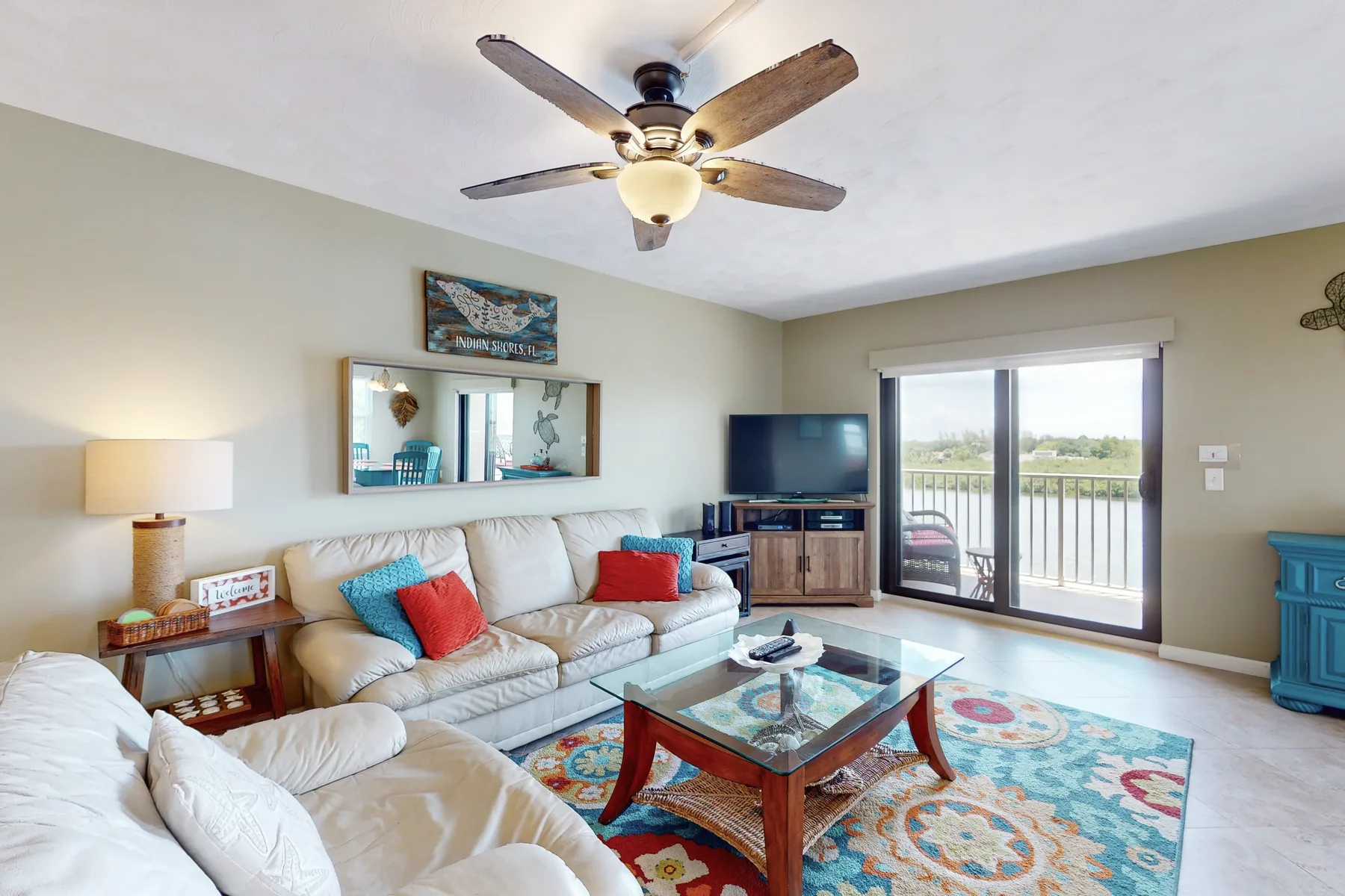 A living room with seating, a glass coffee table, and sliding doors to a balcony.