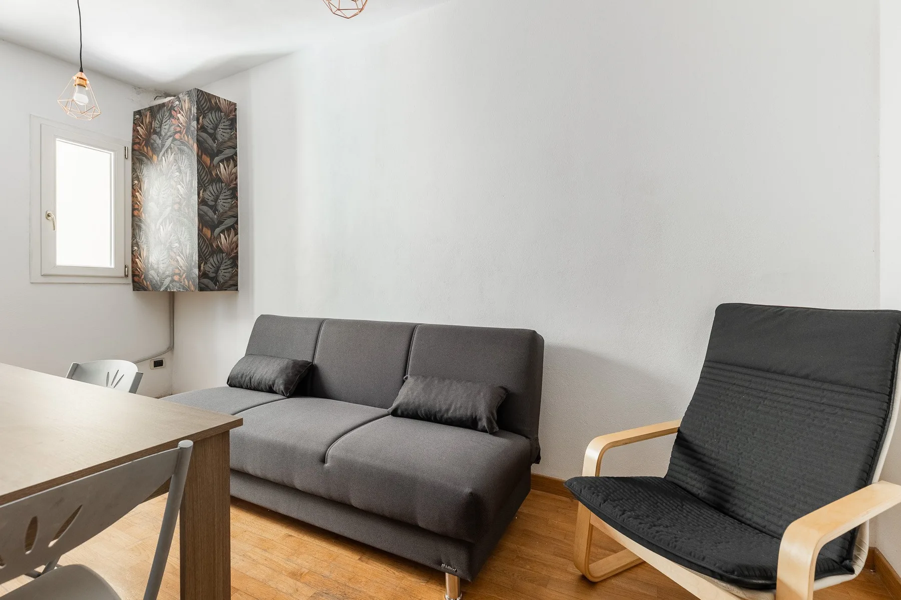 A living room with a gray sofa and a black lounge chair.