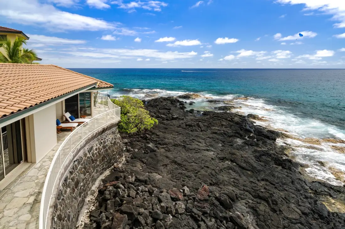 Una casa junto al mar da a una costa rocosa y al océano azul.