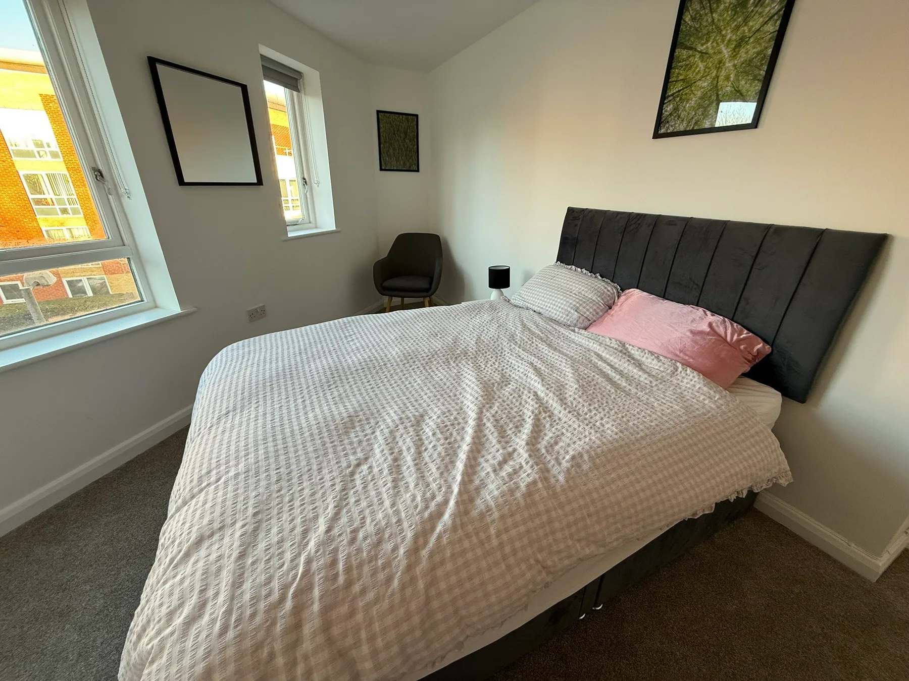 Un dormitorio con una cama, almohadas y ventanas.