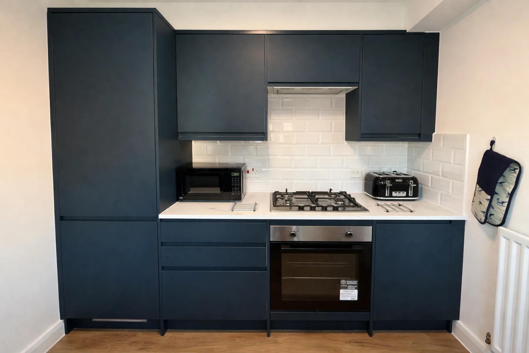 Una cocina compacta con gabinetes oscuros, una estufa y un horno.