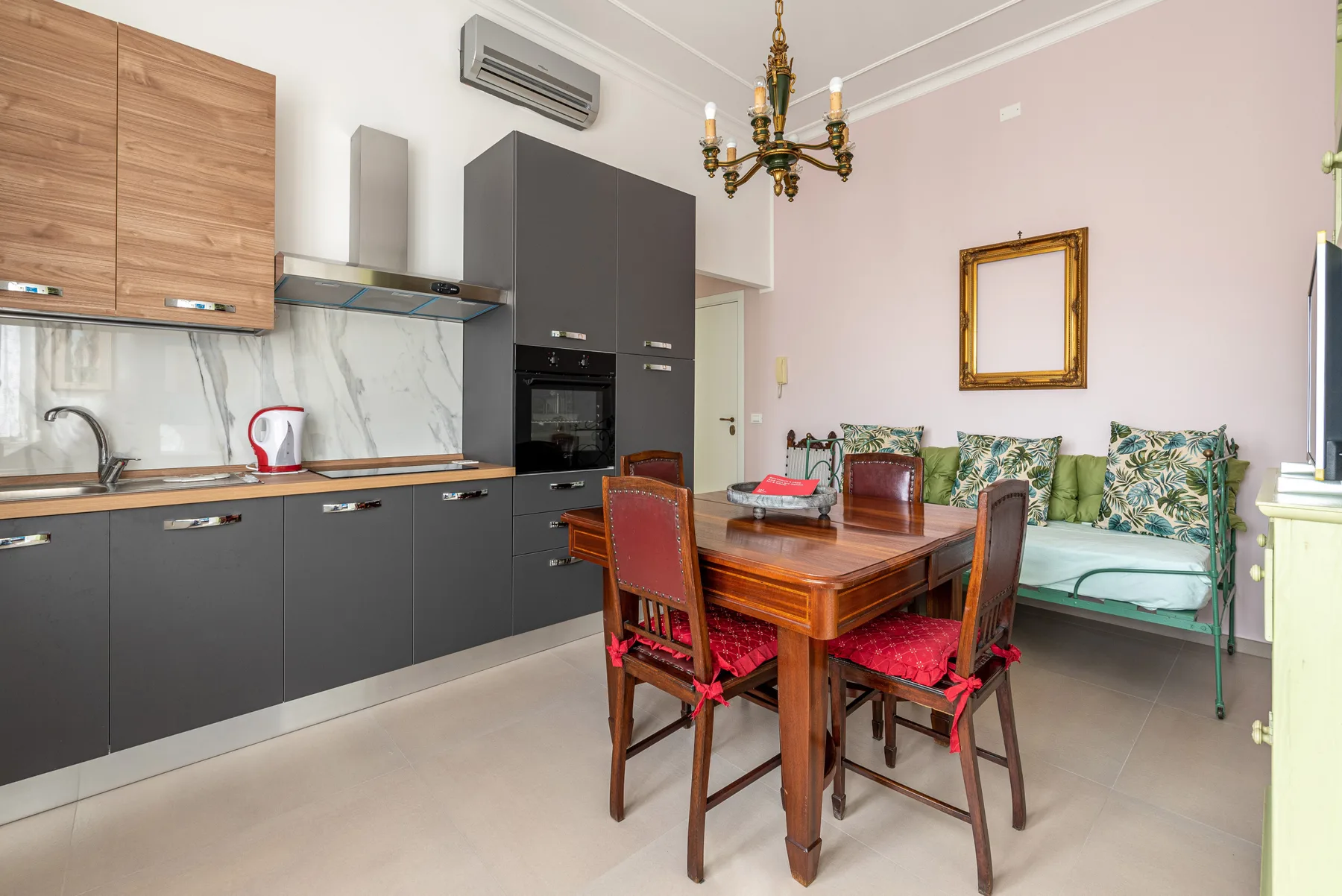 A dining area with a wooden table and chairs beside a modern kitchen.