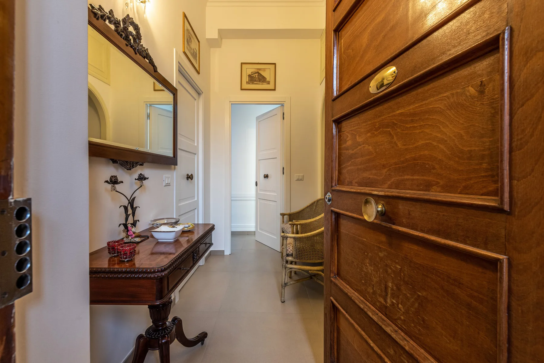 A bright hallway with a wooden console table and an open door.