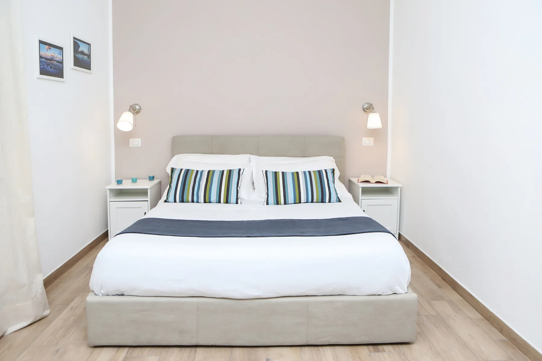 Un dormitorio con una cama tendida y mesas de noche a juego.