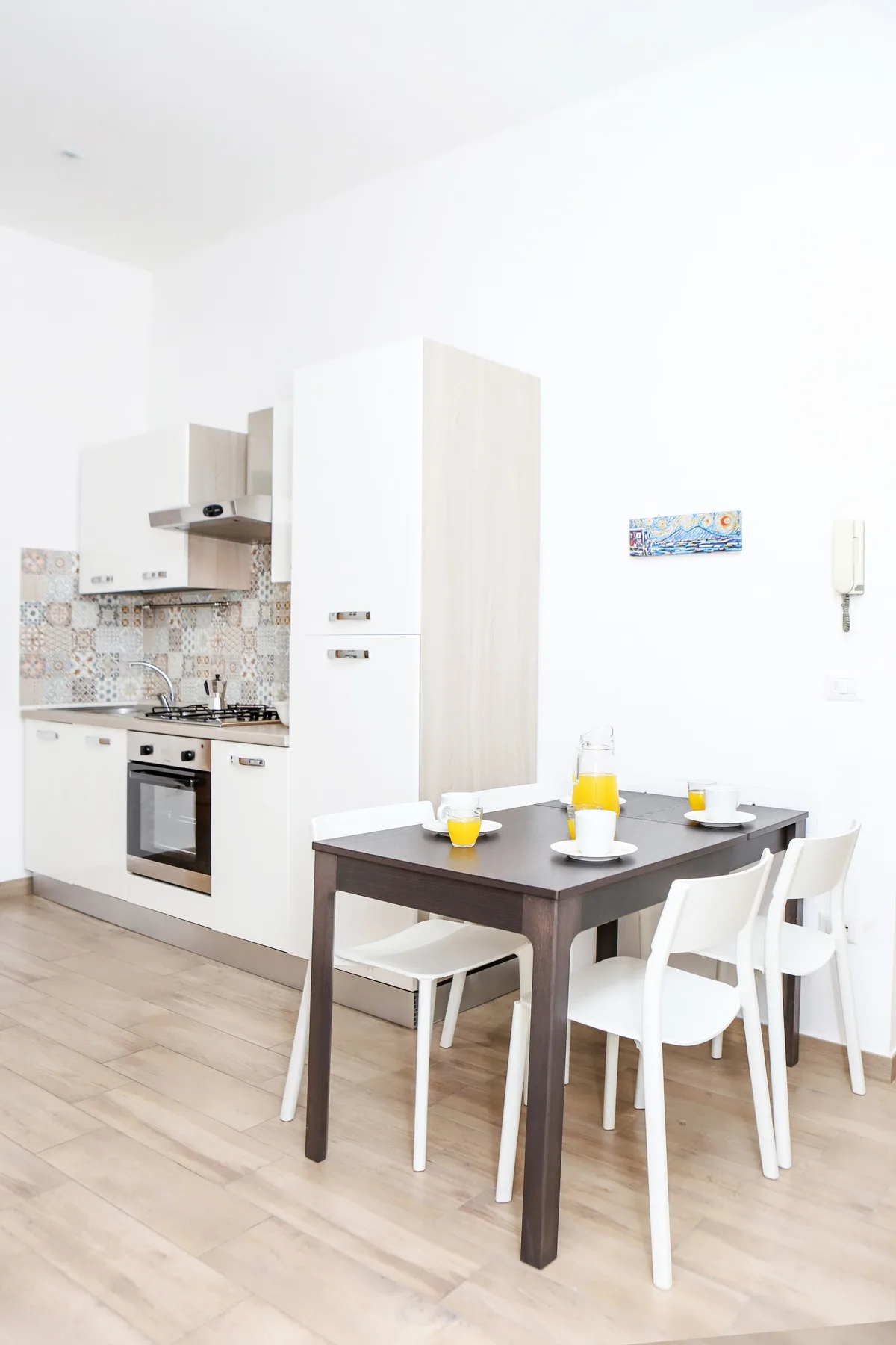 Una cocina luminosa con una mesa oscura y asientos blancos.