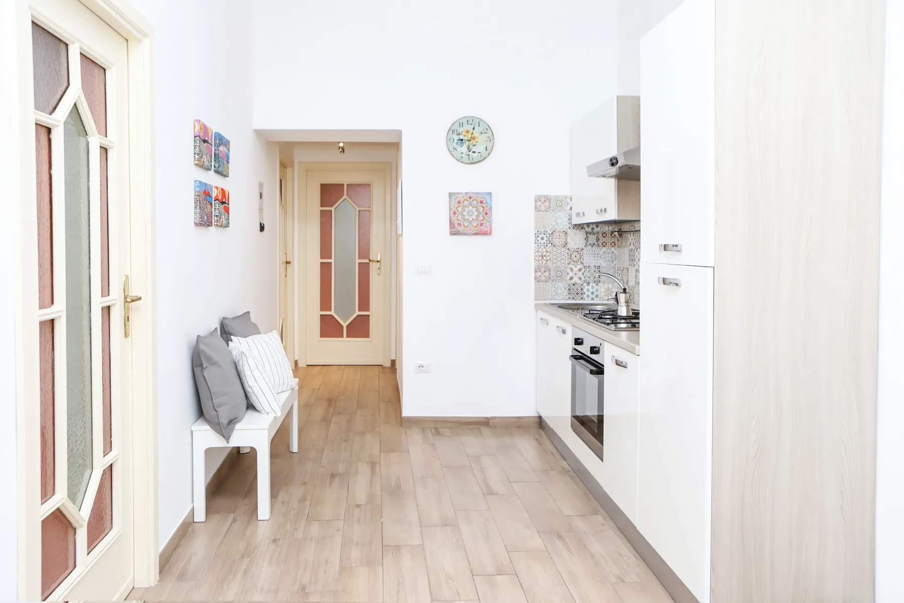 Una cocina y comedor luminosos con un banco estrecho junto a la pared.
