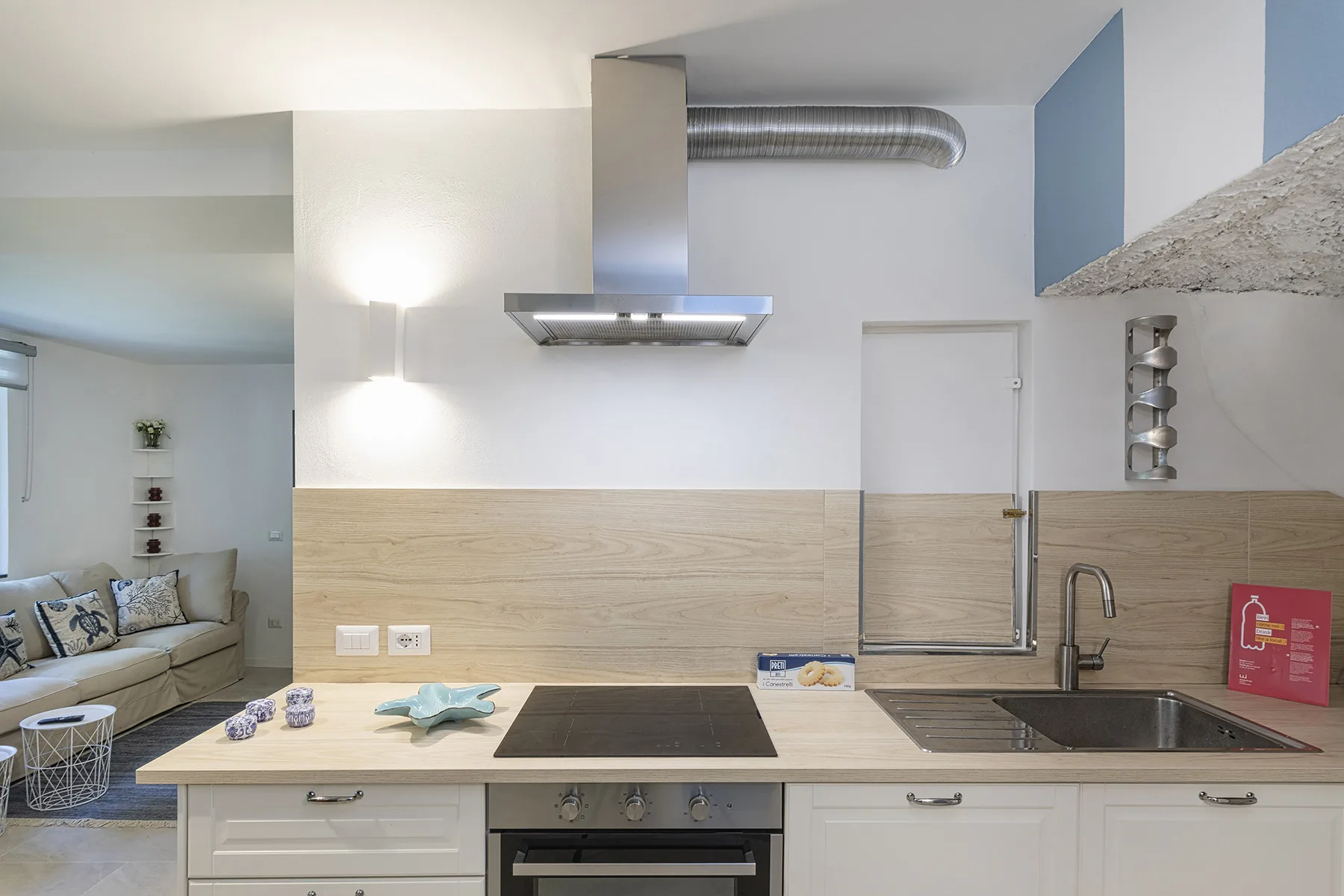 Una cocina con una isla central, una placa de cocina y un fregadero.