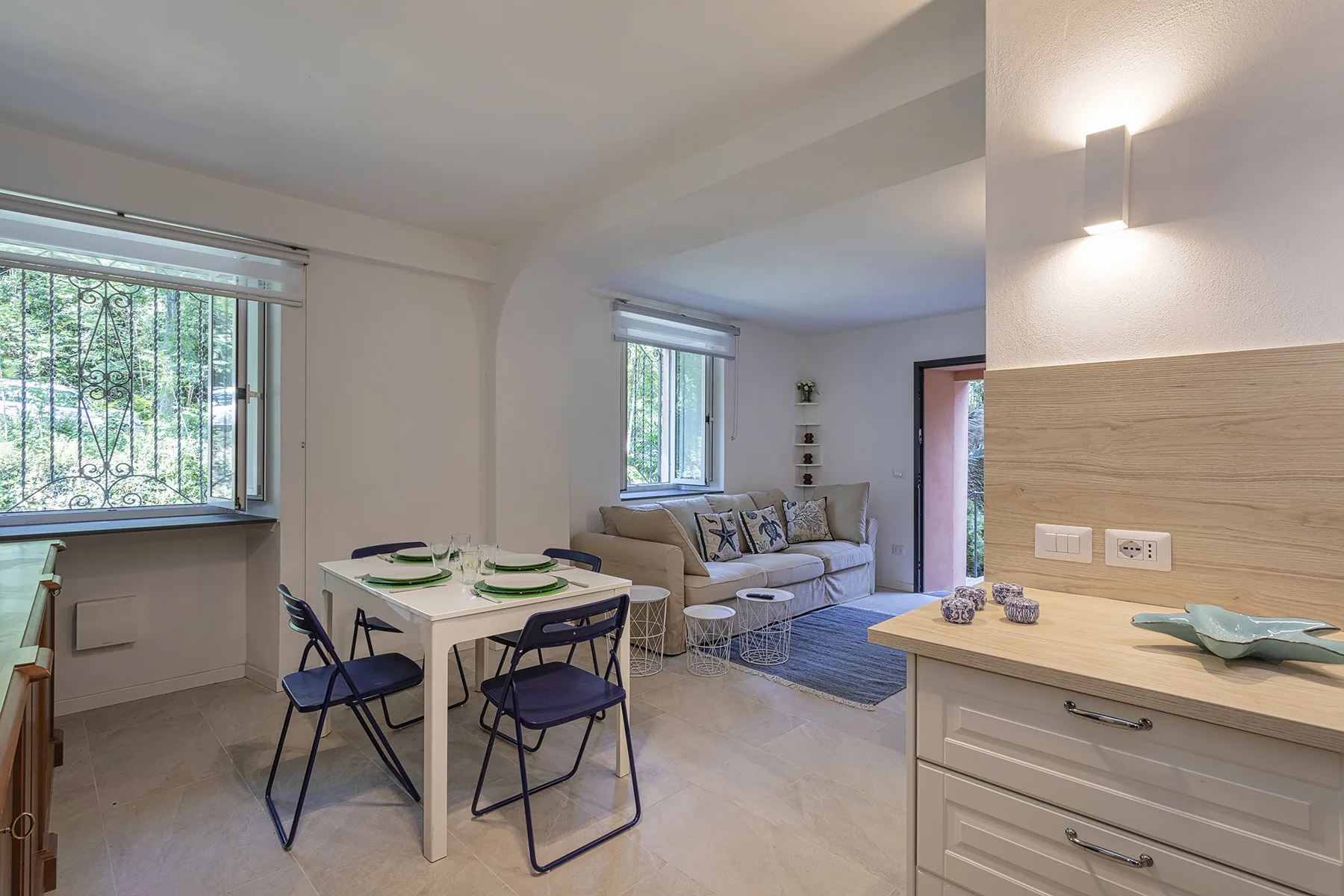 Una luminosa sala de estar y comedor de espacio abierto, con una mesa junto a la zona de asientos.
